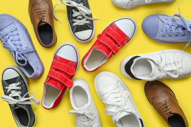 Sarı arka planda farklı çocuk ayakkabıları.