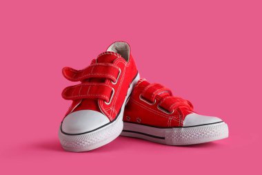 Pembe arka planda kırmızı çocuk ayakkabıları