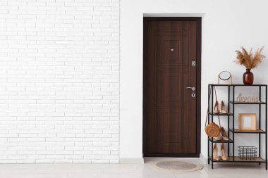 Beyaz duvarın yanında raf ünitesi olan modern koridorun içi.