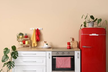 Mutfağın içinde tezgah, buzdolabı ve peçeteler var.