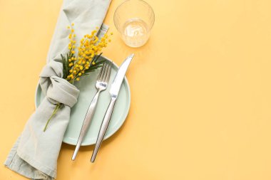 Sarı arka planda mimoza çiçekleri olan güzel bir masa.