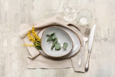 Mimoza çiçekleri ve gri arka planda okaliptüs olan güzel bir masa.