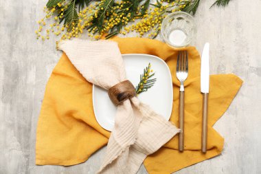 Gri arkaplanda mimoza çiçekleri olan güzel bir masa.