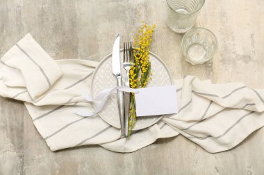 Boş kart ve gri arka planda mimoza çiçekleri ile güzel masa ayarları