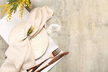 Gri arkaplanda mimoza çiçekleri olan güzel bir masa.