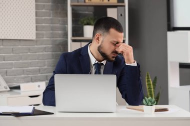 Genç işadamı ofiste kendini kötü hissediyor.