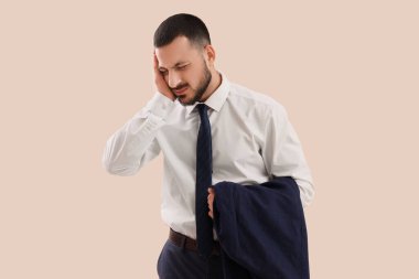 Genç işadamı ışık arka plan üzerinde baş ağrısı muzdarip