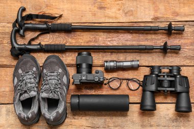 Ahşap zemin üzerinde seyahat malzemeleri, ayakkabılar ve fotoğraf makinesi olan kompozisyon