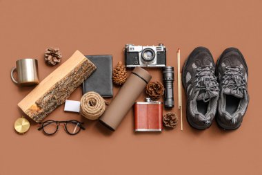 Modern termos, ayakkabı, farklı seyahat ögeleri ve renk arkaplan üzerinde çam kozalakları ile kompozisyon