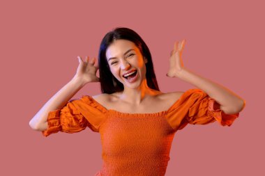 Kırmızı arka planda mutlu, güzel bir kadın.