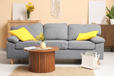 Mimoza çiçekli vazo ve gazete oturma odasının içindeki masada.