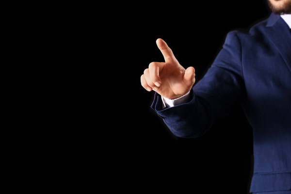 Бизнесмен использует виртуальный экран на темном фоне, крупным планом. Концепция цели