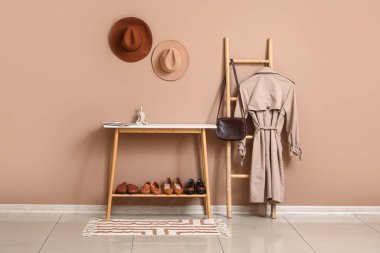 Modern koridorun iç tarafında kahverengi duvarın yanında duran ayakkabı ve merdiven için ayakta durun.