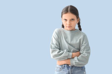 Mavi arka planda karın ağrısı çeken tatlı bir kız.