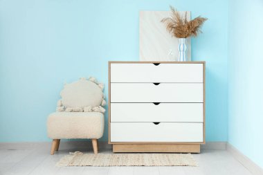 Çimenli vazo ve mavi duvarın yanındaki beyaz klozette boya.