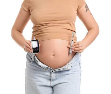 Beyaz arka planda glukometresi ve tükenmez kalemi olan hamile bir kadın. Gebelik Diyabet Konsepti