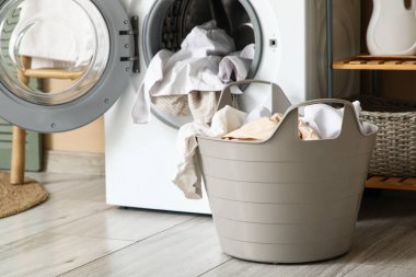 Çamaşır odasında çamaşır makinesinin yanında kirli çamaşırlarla dolu sepet.