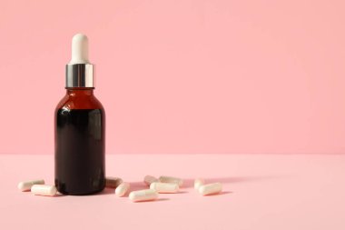 İyot şişesi ve pembe arka planda haplar.