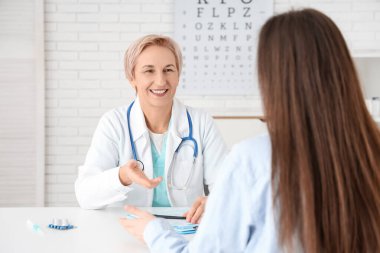 Klinikte hastası olan mutlu bir kadın doktor.