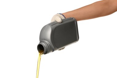 Beyaz arka planda şişeden makine yağı dökülüyor.