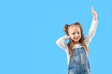 Mavi arka planda gülümseyen at kuyruklu şirin küçük kız.