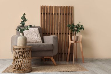 Oturma odasının içinde koltuk, masa ve katlanır ekran var.