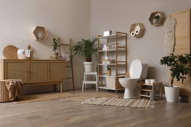 Tuvalet klozeti ve rafları olan bir tuvalet.