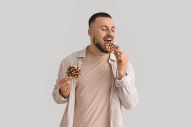 Genç adam arka planda kurabiye yiyor.