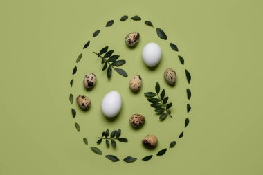 Yeşil arka planda yaprakları olan Paskalya yumurtaları