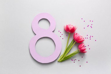 Şekil 8 kağıt, güzel lale çiçekleri ve gri arka planda konfeti. Uluslararası Kadınlar Günü kutlamaları