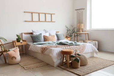 Büyük yataklı ve masalı aydınlık yatak odasının içi.