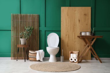 Tuvalet klozeti, masaları ve katlanan ekranı olan bir tuvalet.