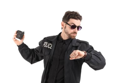 Elinde kahve olan erkek polis memuru beyaz arka planda kol saatine bakıyor.