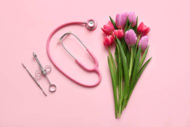 Pembe arka planda cerrah aletleri olan güzel lale çiçekleri. Uluslararası Kadınlar Günü kutlamaları