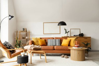 Oturma odasının içinde kahverengi deri kanepe, koltuk, tuvalet ve sehpa var.