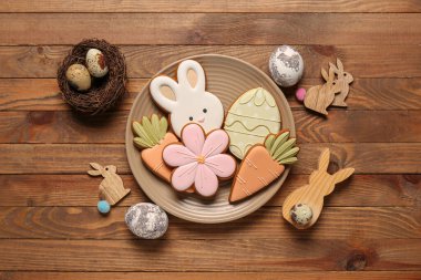 Ahşap zemin üzerinde farklı Paskalya kurabiyeleri olan dekor ve tabak.