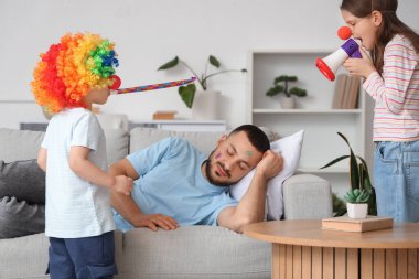 Evde babalarına bağıran megafonlu küçük çocuklar. 1 Nisan şakası.