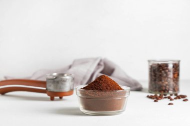 Beyaz arka planda iskele filtresi olan bir kase kahve tozu.