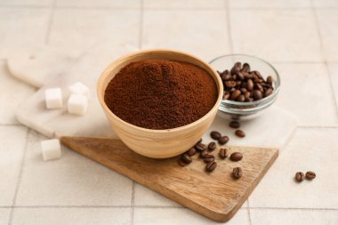 Üzerinde kahve tozu, fasulye ve şeker küpleri olan tahta.