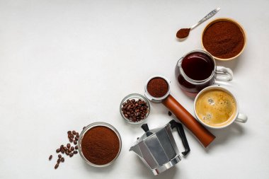 Barut, fasulye, sürahi, portafilter ve beyaz arka planda gayzer kahve makinesi olan bir fincan kahve.