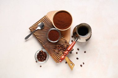 Fasulyeli kahve tozu ve açık arkaplanlı kahve kaseleri.