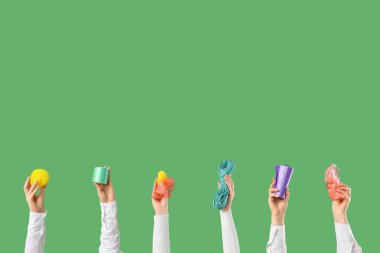 Yeşil arka planda farklı plastik parçaları olan kadın eller. Kirlilik kavramı