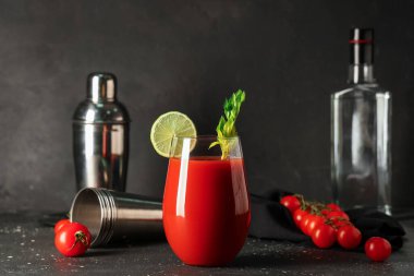 Kereviz, limon dilimi ve siyah grunge arkaplanda domatesli bir bardak Bloody Mary.
