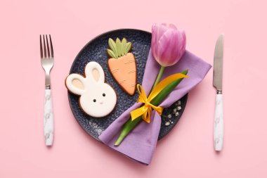 Tatlı kurabiyeler ve pembe arka planda lale çiçeğiyle güzel bir masa.