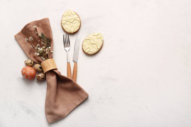 Beautiful table setting with sweet cookies, Easter eggs and pussy willow branches on white background