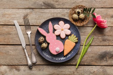 Tatlı kurabiyeler, bıldırcın yumurtaları ve ahşap arka planda lale çiçekleri olan güzel bir masa. Paskalya kutlaması