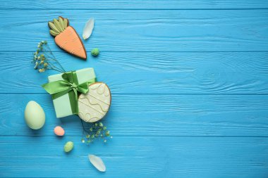 Hediye kutusu, dekor, mavi ahşap arka planda Paskalya yumurtası ve kurabiye kompozisyonu