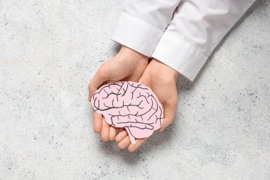 Hafifmeşrep arka planda kağıt insan beyni tutan kadın eller. Kanser kavramı