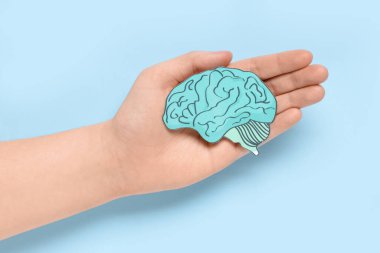 Mavi arka planda kağıt insan beyni tutan bir kadın. Kanser kavramı