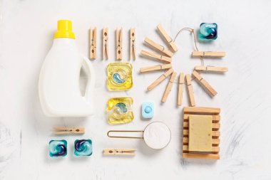 Çamaşır deterjanlı ahşap mandallar ve beyaz arka planda sabun.